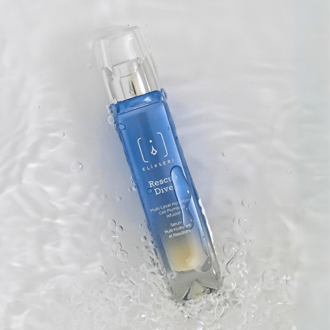 A blue glass bottle of Elixseri Rescue Diver serum in a pool of water