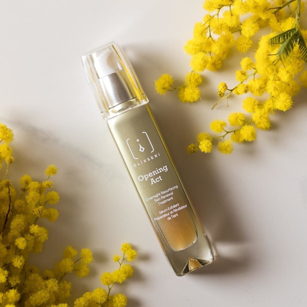 Opening Act skin renewal anti-ageing serum pictured surrounded by mimosa flowers