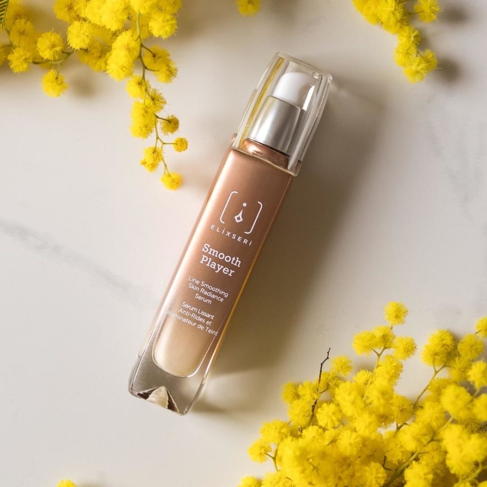 Smooth Player anti-ageing detox serum surrounded by yellow mimosa