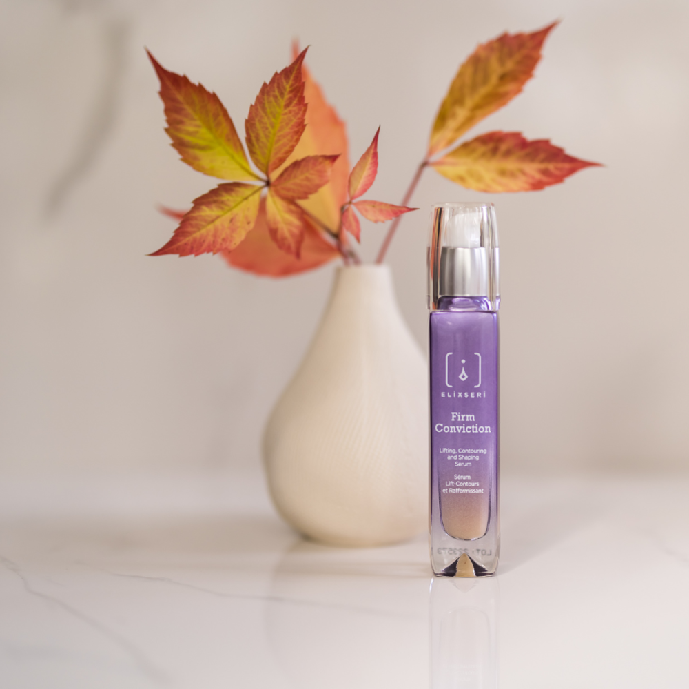 Elixseri Firm Conviction Lifting and firming serum in front of a white vase with red Autumn leaves