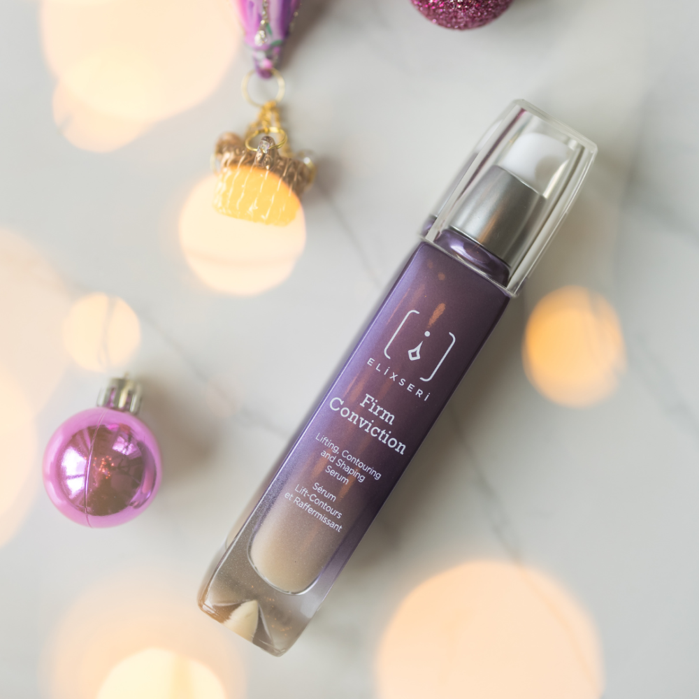 Purple Firm Conviction bottle on a festive background with purple Christmas decorations