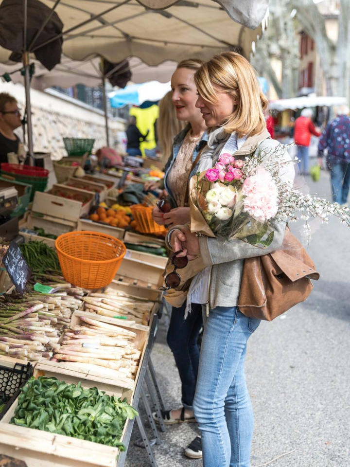Une femme blonde faisant ses courses au marché du village d'Aix-en-Provence