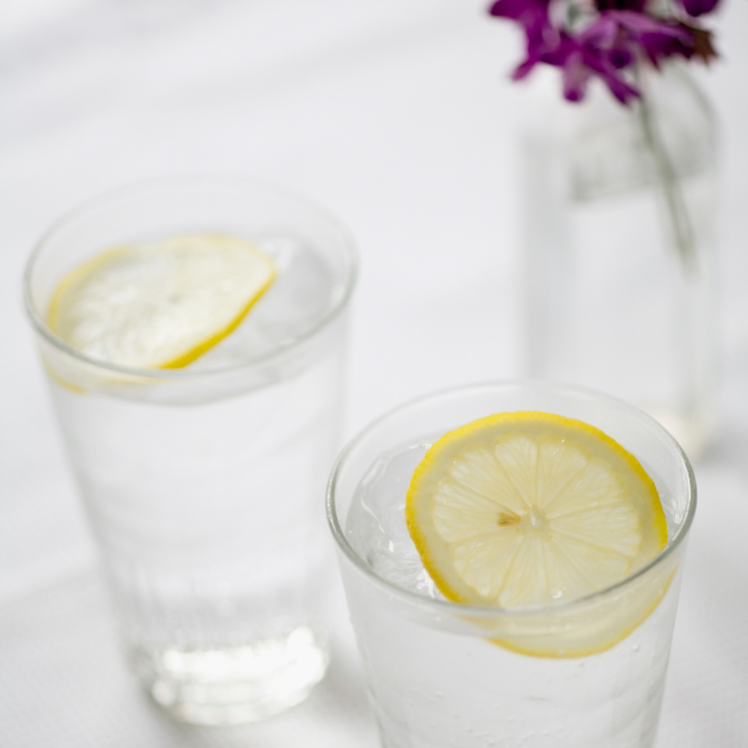 Two glasses of water with fresh lemon slices and ice.