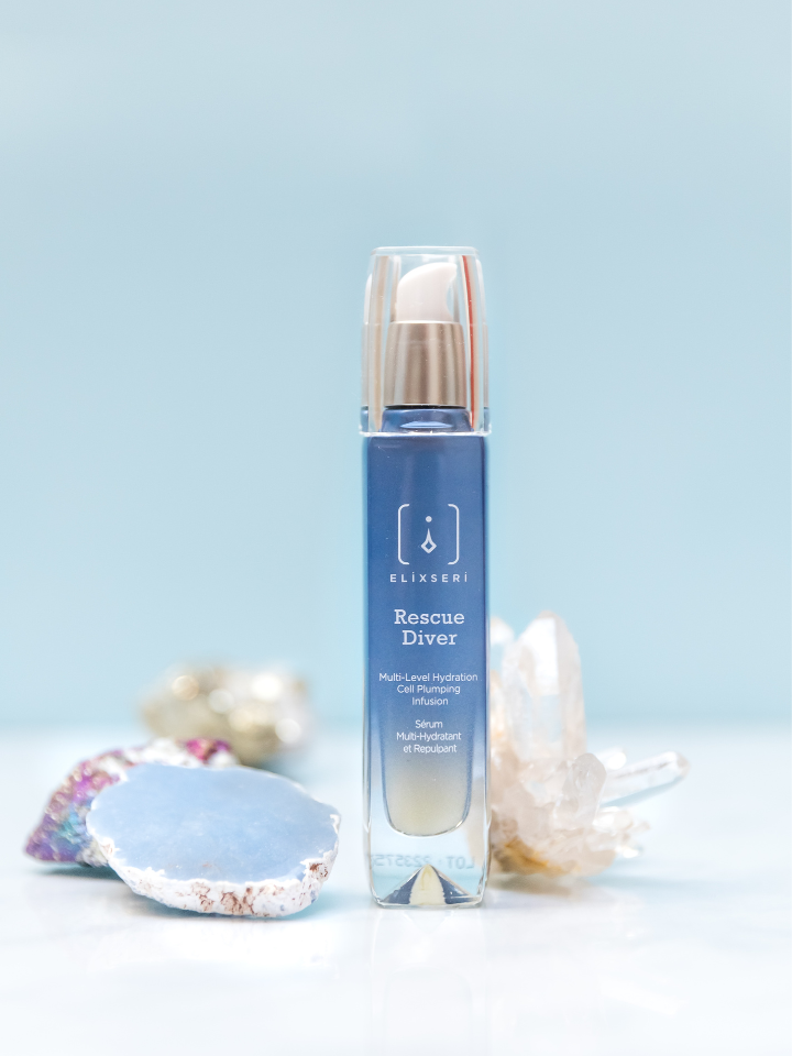 Elixseri Rescue Diver hydrating serum standing amongst crystals. Multi-level hydration cell plumping infusion.
