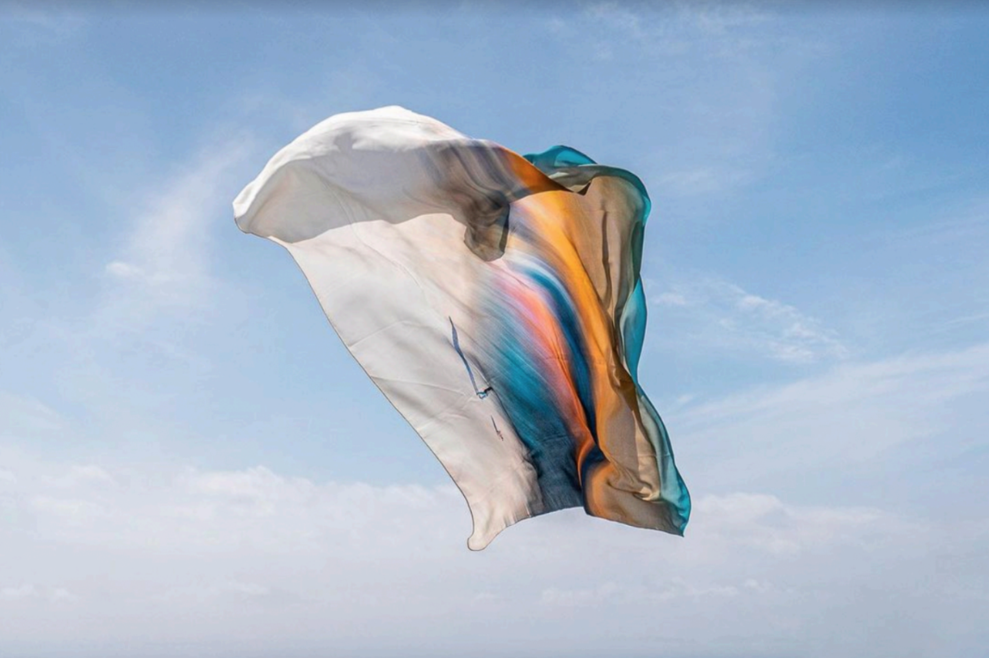 A Granite Island scarf floating in the blue sky. The beautiful watercolour design glows in the light