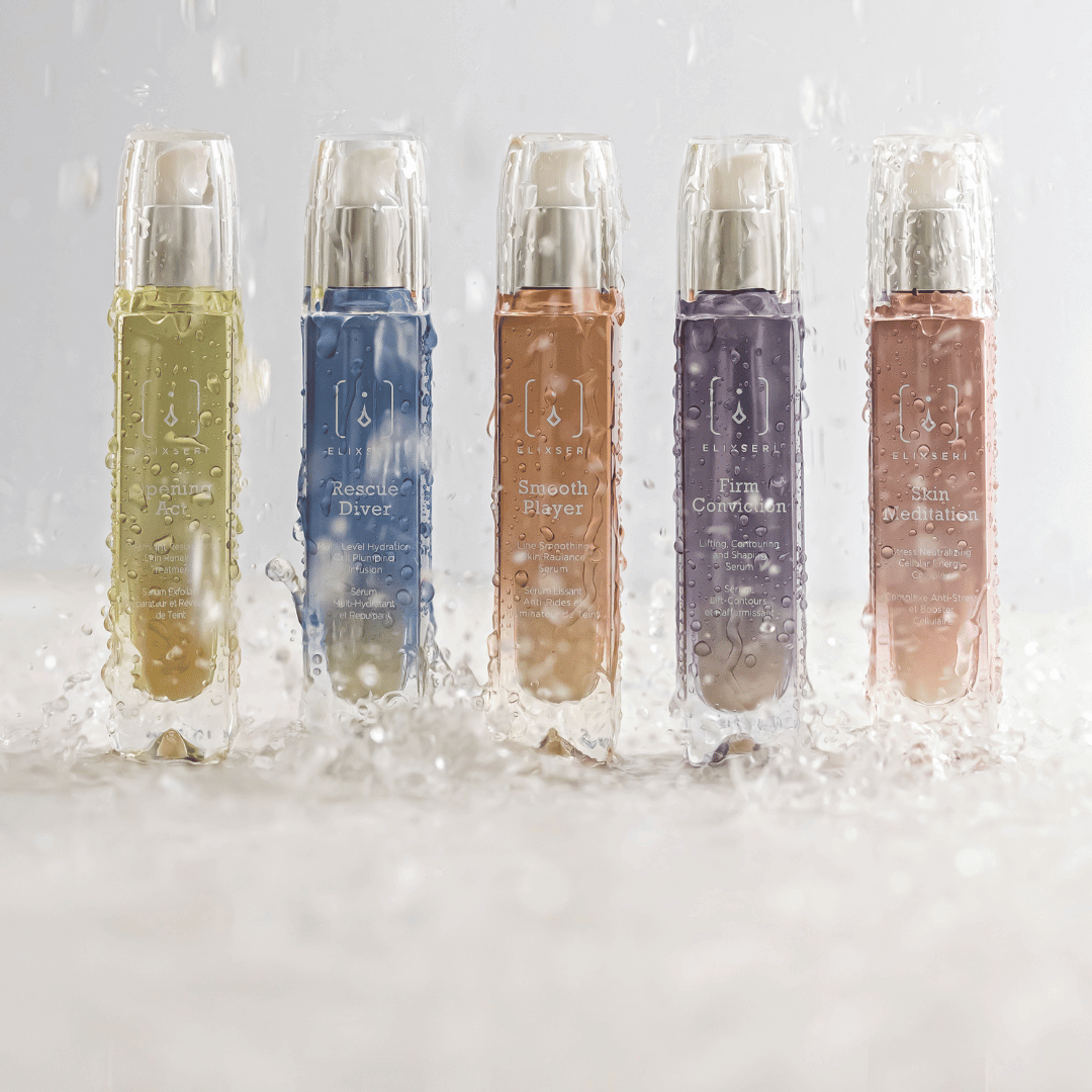 Dry skin vs dehydrated skin. Elixseri serums lined up in a row with water being poured over them against a grey bakground.