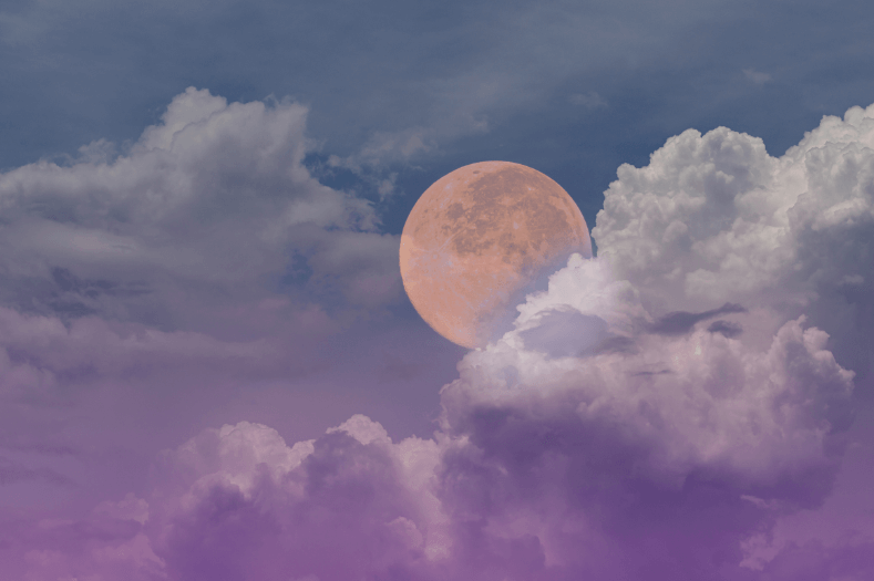 A yellow full moon in a cloudy purple and blue night time sky