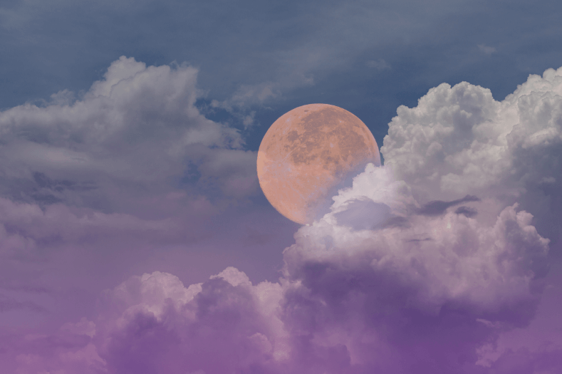 Une pleine lune jaune dans un ciel nocturne nuageux violet et bleu.