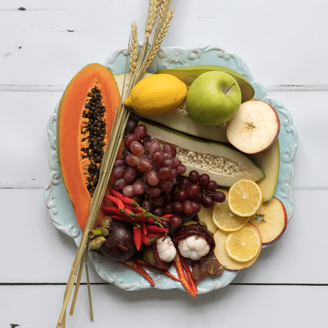 Une assiette de fruits frais comprenant des oranges, des papayes et des citrons. Fruits AHA