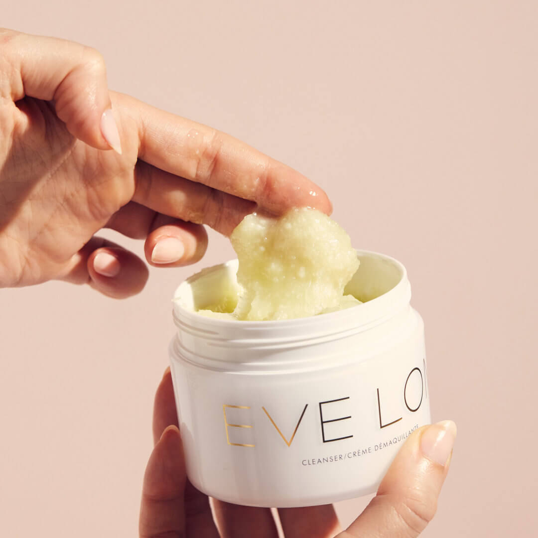 A woman with Eve Lom cleanser in her hand