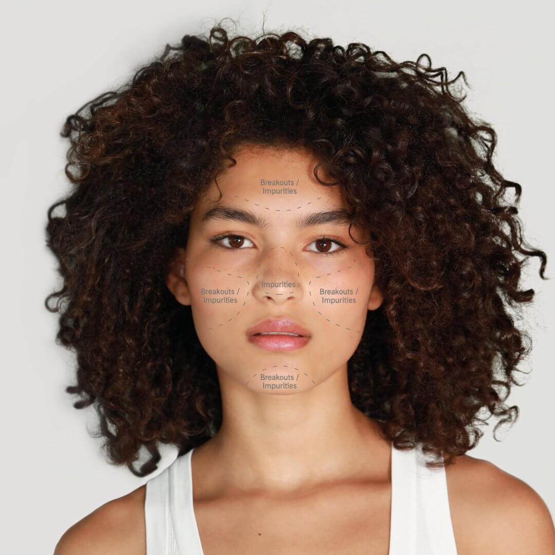 A tanned brunette lady with her skin concerns written on her face to establish and explain her skin type. 